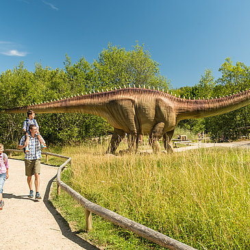 Das Bild zeigt eine Familie im Dinopark Teufelsschlucht.
